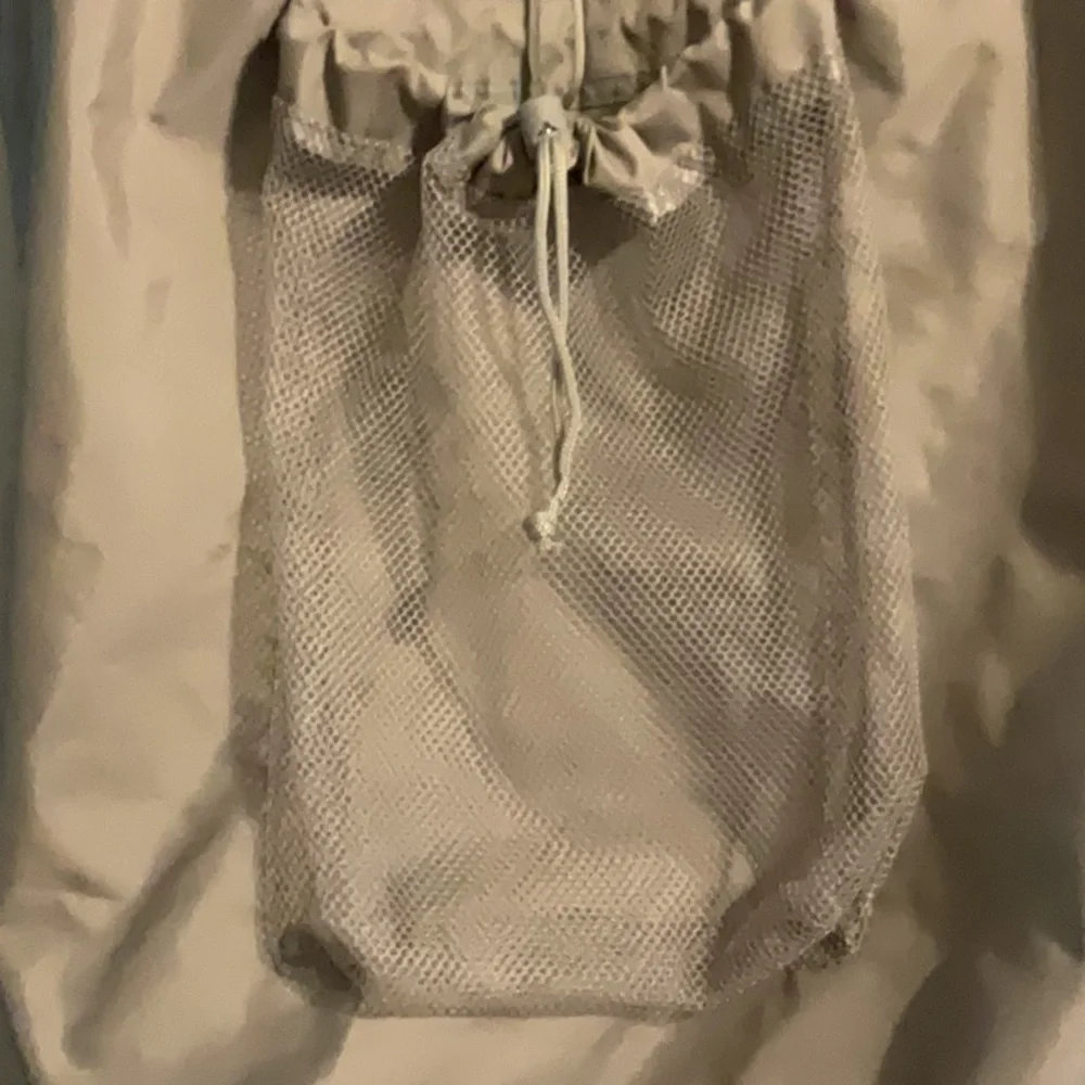 Large gray laundry bag with handle and backpack straps. Front and inside pockets